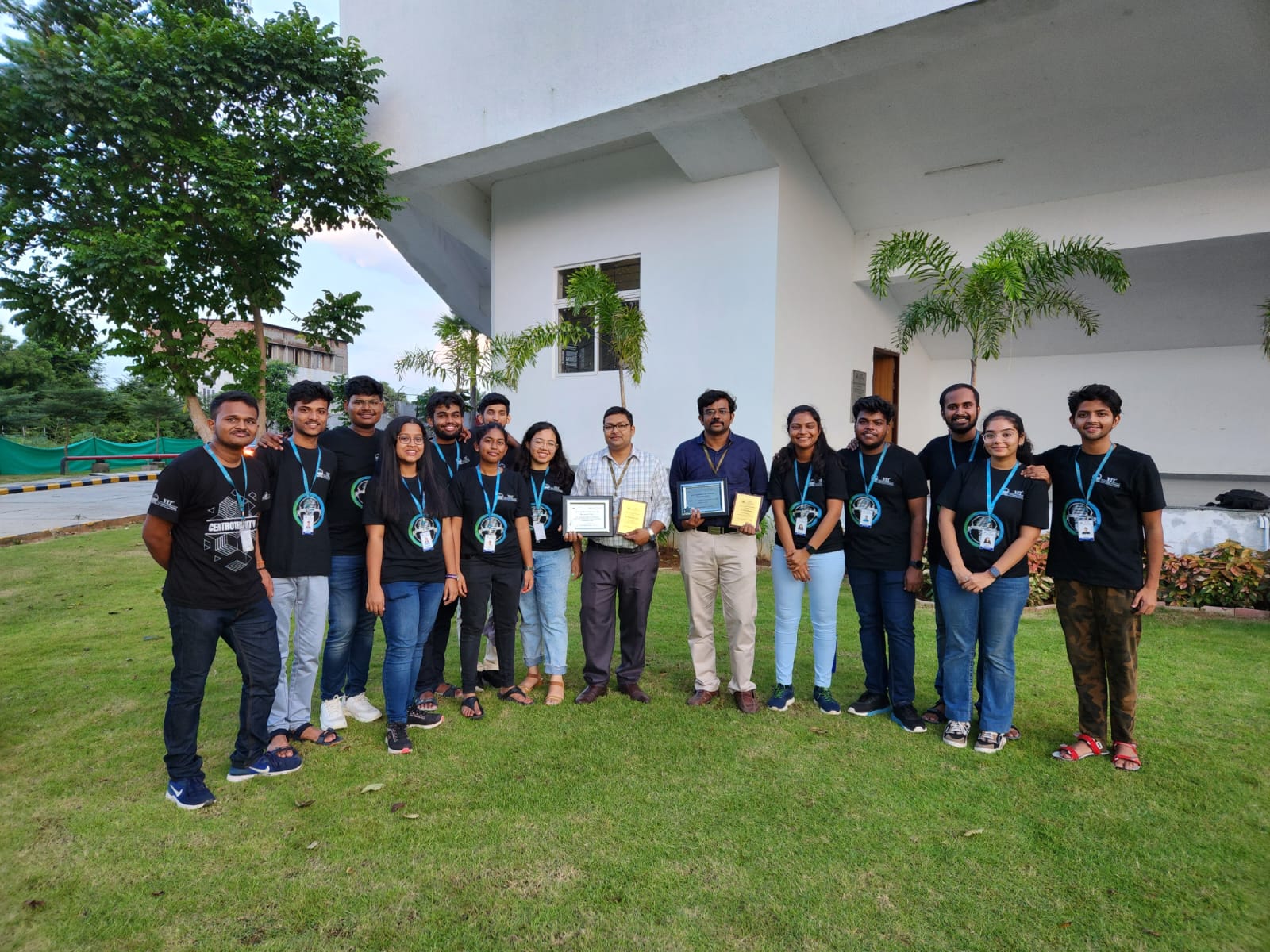 Dr. Pritam Bhowmik with a student team holding recognition plaques outdoors